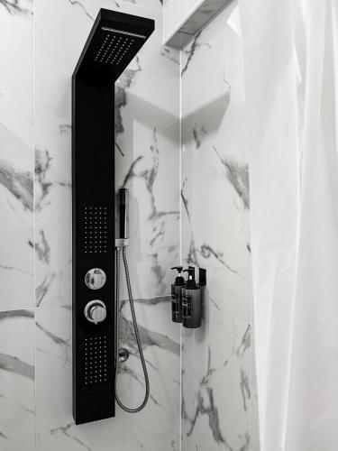 a shower in a bathroom with white marble walls at GoldMar Beach Apartments - Praia da Vieira in Vieira de Leiria