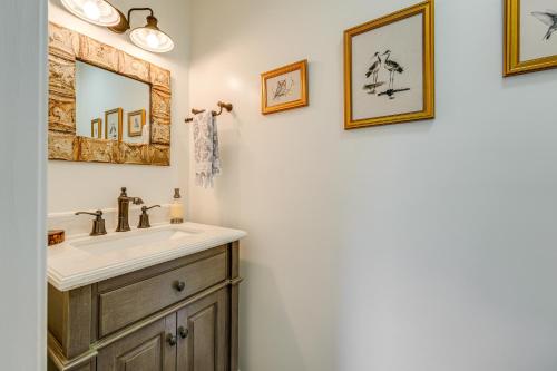 a bathroom with a sink and framed pictures on the wall at Kennebec River Retreat Less Than 5 Mi to Popham Beach in Phippsburg