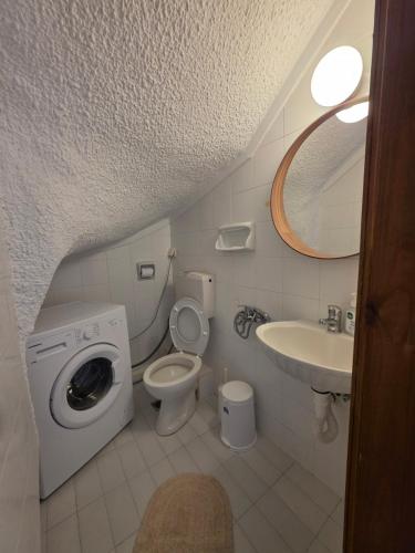 a bathroom with a washing machine and a sink at Bright & Bloom maisonette in Hanioti