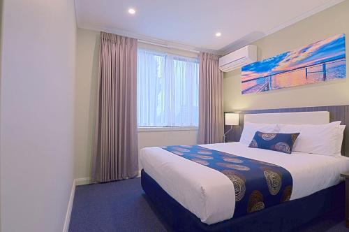 um quarto de hotel com uma cama e uma janela em Park Squire Motor Inn & Serviced Apartments em Melbourne