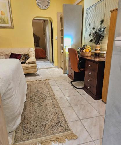a bedroom with a bed and a desk and a couch at RPG Corporate Unit in Johannesburg
