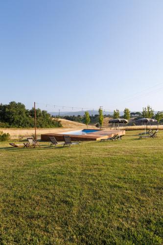 a group of park benches in a grass field at Tenuta La Santissima in San Rocco a Pilli