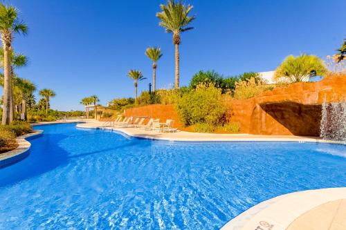 a swimming pool with a waterfall and palm trees at Luau I 6710 in Destin
