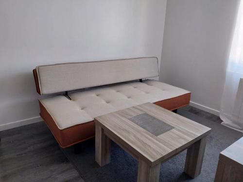 un banc avec une table dans une pièce dans l'établissement Le Figuier, au Mans