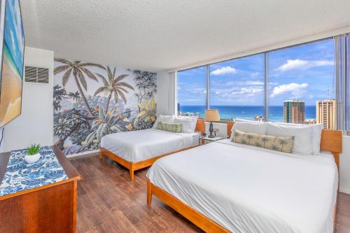 a bedroom with two beds and a view of the ocean at Hawaiian Monarch Penthouse 401 by Hawaii Ocean Club in Honolulu