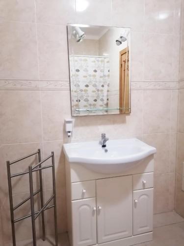 a bathroom with a white sink and a mirror at Casa Vila Rosa - T1 Altura Beach in Altura