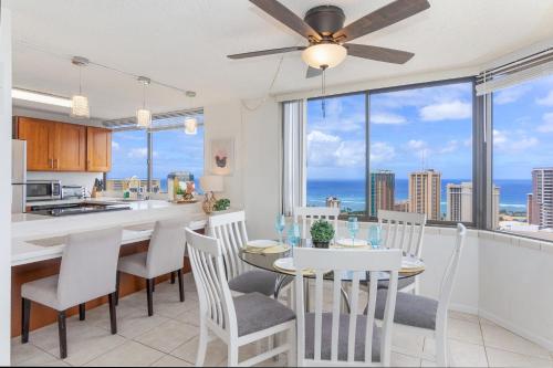 a kitchen and dining room with a table and chairs at Hawaiian Monarch Penthouse 401 by Hawaii Ocean Club in Honolulu