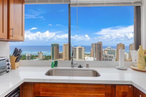 a kitchen with a sink and a large window at Hawaiian Monarch Penthouse 401 by Hawaii Ocean Club in Honolulu