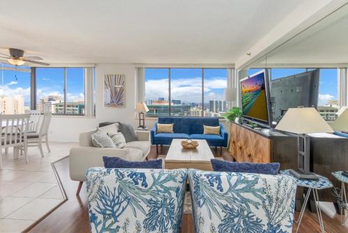 a living room with a couch and a tv at Hawaiian Monarch Penthouse 401 by Hawaii Ocean Club in Honolulu