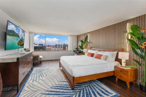 a bedroom with a bed and a large window at Hawaiian Monarch Penthouse 401 by Hawaii Ocean Club in Honolulu