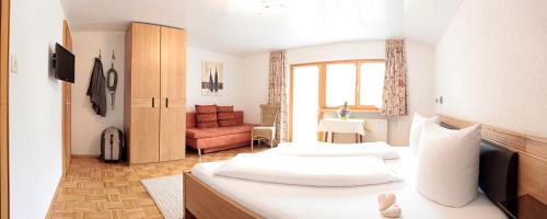 a hotel room with two beds and a chair at Bergkristall in Brand