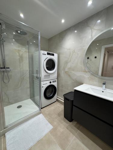 une salle de bain avec une machine à laver et un lavabo dans l'établissement Appartement vue mer 45m2 avec grande terrasse 20m2, à La Baule