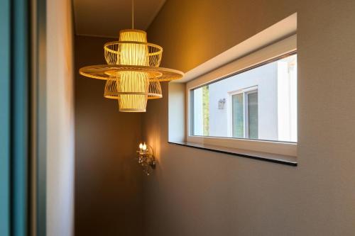 a room with two chandeliers and a window at Spain House in Namhae