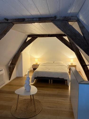 a attic bedroom with a bed and a table at Au bât Tournai Appart in Tournai