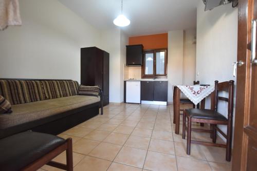 ein Wohnzimmer mit einem Sofa und einem Tisch in der Unterkunft Pansion Fani in Ouranoupoli