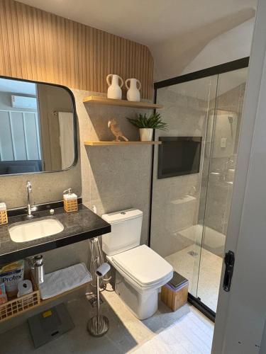 a bathroom with a toilet and a sink and a shower at Refúgio com Pé na Areia in Mata de Sao Joao
