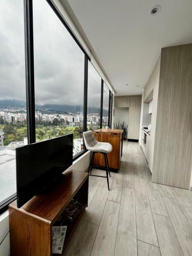 a living room with large windows and a television at STUDIO Luxury View Edificio Harmony in Quito