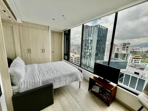 a bedroom with a bed and a view of a city at STUDIO Luxury View Edificio Harmony in Quito