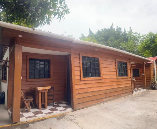 a small wooden cabin with a table and a table at Cabañas El NaranjitoX 