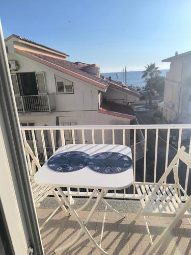 a white chair with a pair of glasses on a balcony at L'Angolo sul mare in Nicotera Marina