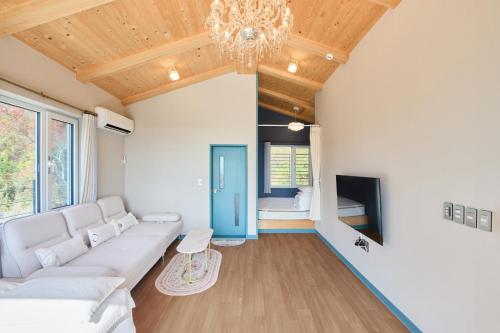 a living room with a white couch and a chandelier at Spain House in Namhae
