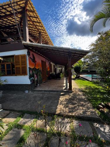 a house with a wooden pergola next to a yard at Casa em Engenheiro Paulo de Frontin in Engenheiro Paulo de Frontin
