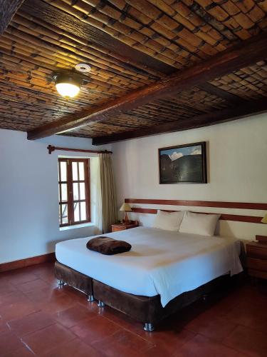 a bedroom with a large bed with a wooden ceiling at Hotel Fundo Achamaqui in Chachapoyas