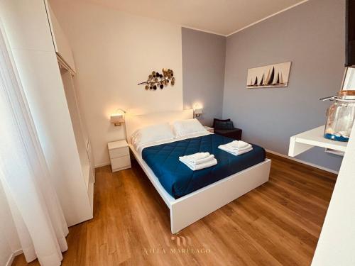 a small bedroom with a bed with blue sheets at Villa Marelago Guest House in Lido Di Fondi