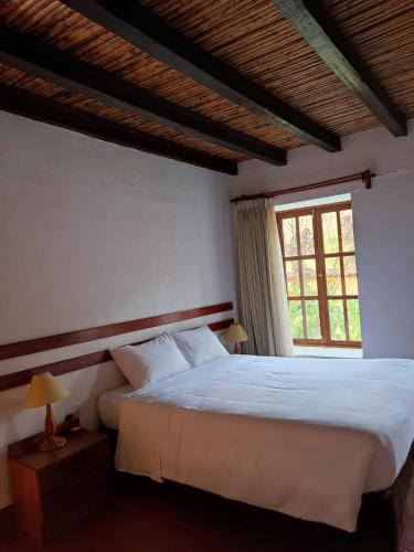 a bedroom with a large bed and a window at Hotel Fundo Achamaqui in Chachapoyas