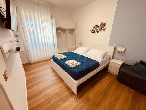 a bedroom with a bed with a blue blanket at Villa Marelago Guest House in Lido Di Fondi