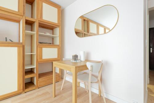 une salle à manger avec une table et un miroir dans l'établissement CASTEL SAINT CLAIR Magnifique Studio plein centre avec Parking, à Deauville