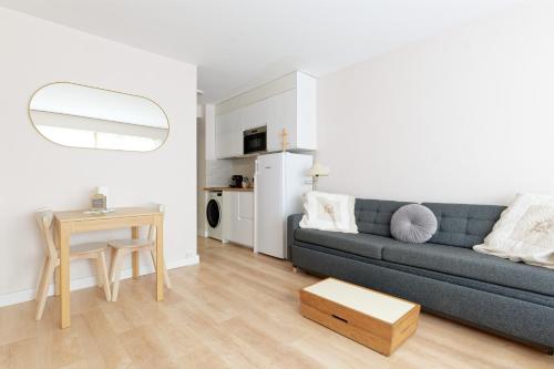 un salon avec un canapé bleu et une table dans l'établissement CASTEL SAINT CLAIR Magnifique Studio plein centre avec Parking, à Deauville