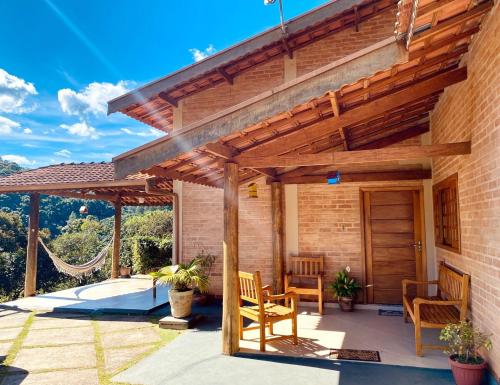 a patio with a wooden pergola and two chairs at Casa em Santo A do Pinhal, vizinha à Campos do Jordão in Santo Antônio do Pinhal