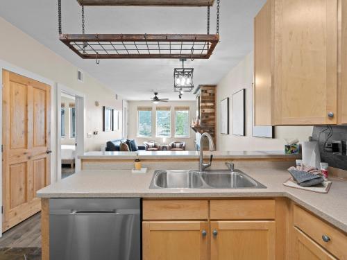a kitchen with a stainless steel sink and wooden cabinets at Crestview Condominiums by All Seasons Resort Lodging in Park City