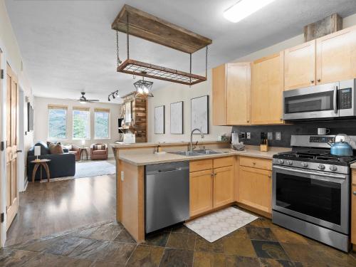 a kitchen with a sink and a stove top oven at Crestview Condominiums by All Seasons Resort Lodging in Park City