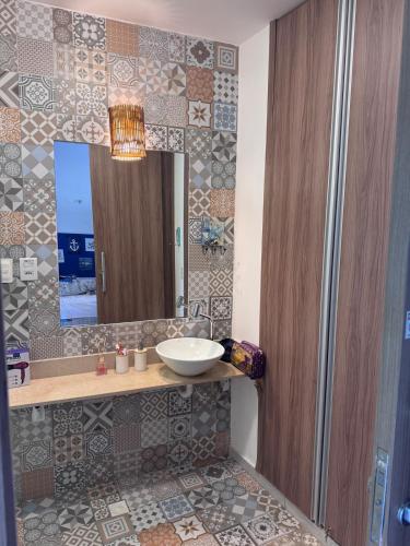 a bathroom with a sink and a mirror at Flat Palmeira-Pipa Solar - centro in Tibau do Sul