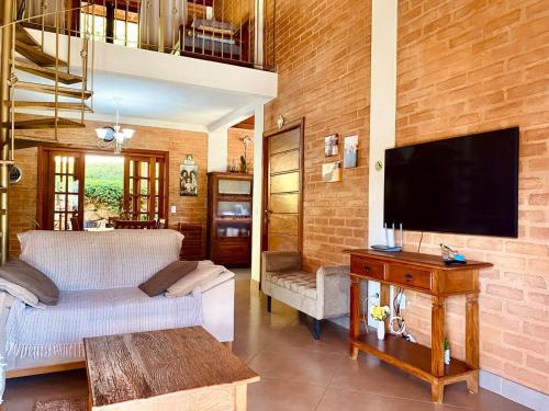 a living room with a couch and a flat screen tv at Casa em Santo A do Pinhal, vizinha à Campos do Jordão in Santo Antônio do Pinhal