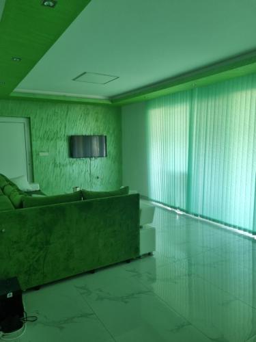 a living room with green walls and a couch at Bovan GREEN LAKE apartments in Soko Banja