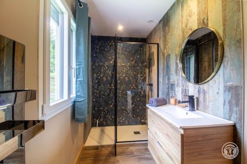 a bathroom with a shower and a sink and a mirror at Villa Malinat entre Val d'Azun et Vallée des Gaves in Arcizans-Avant