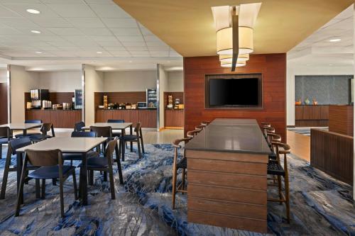 a conference room with tables and chairs and a flat screen tv at Fairfield Inn & Suites by Marriott St. Louis Pontoon Beach/Granite City, IL in Collinsville