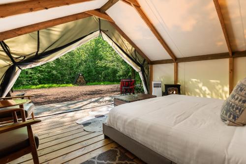 a bedroom in a tent with a bed and a fireplace at The Fields of Michigan in South Haven