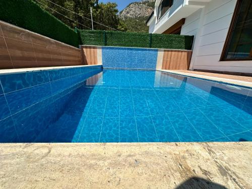 a swimming pool with blue tile in a house at Relax 1 Lüks villa in Kemer