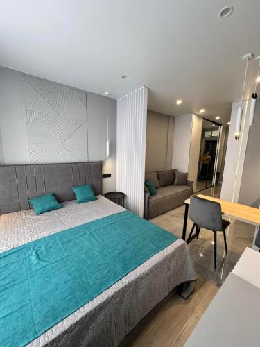 a bedroom with a large bed and a couch at Сучасні апартаменти в новобудові in Lviv