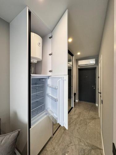 a walk in closet with white cabinets and drawers at Сучасні апартаменти в новобудові in Lviv