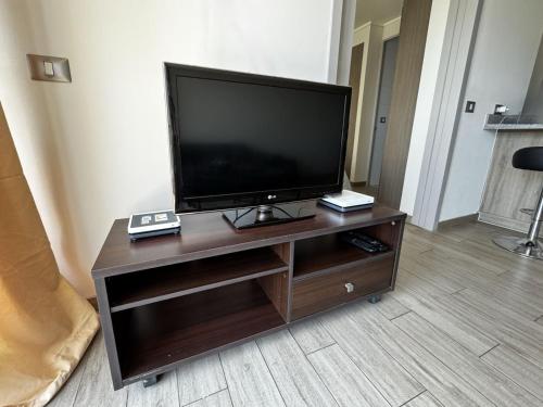 a flat screen tv sitting on top of a wooden entertainment center at Departamento Centro Vista al mar 1D 1B in Antofagasta
