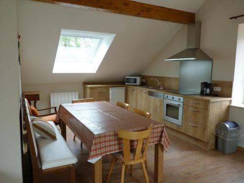 a kitchen with a table and chairs and a kitchen with a window at Logis Hôtel Notre-Dame - restaurant ouvert midi et soir sauf dimanche soir in Danne-et-Quatre-Vents