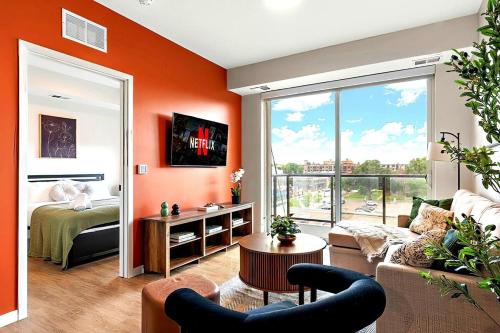 a living room with orange walls and a room with a bed at W513 Cozy & Chic 1Bd In Downtown Minneapolis, Minutes From Minneapolis Convention Center & US Bank Arena in Minneapolis