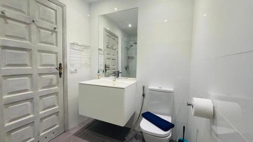 a white bathroom with a toilet and a sink at Casa Charlotte El Cotillo in El Cotillo