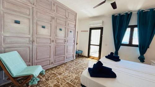 a bedroom with two beds and a blue chair at Casa Charlotte El Cotillo in El Cotillo