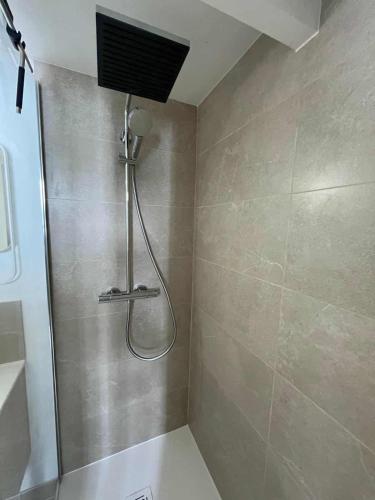 une douche avec pommeau de douche dans une salle de bain dans l'établissement Sea Sun Cocoon, à La Rochelle
